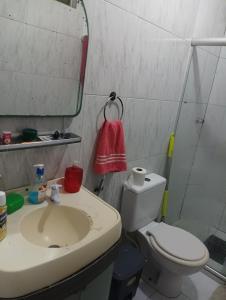 a bathroom with a sink and a toilet and a mirror at Hóspede se bem e com custo beneficio em Salvador in Salvador