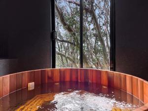 a round bath tub with a window in a room at Lakeside Falls Creek in Falls Creek