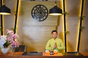 a man sitting at a table in a room at Bali Breezz Hotel in Jimbaran