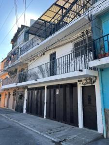 a white building with black doors and a balcony at Hostal 17-52 in Guatemala