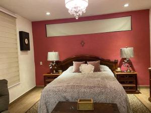 1 dormitorio con 1 cama grande y pared roja en CASA ENSUEÑO, en Isla de La Pacanda