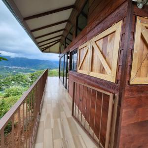 Un balcón de una casa con puertas de madera en Cabañas Vista de Oro, en Paraíso