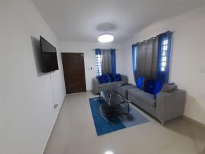 ein Wohnzimmer mit einem Sofa und einem TV in der Unterkunft BRISTOL HOME VILLA! Residencial Naime 3 in San Pedro de Macorís