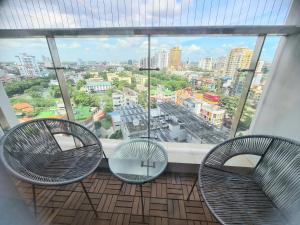 a room with two chairs and a large window at NVT Housing - Vinhomes Metropolis Apartment Hanoi in Hanoi