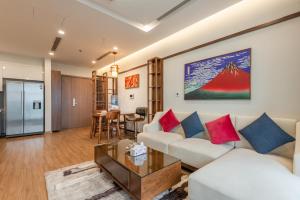 ein Wohnzimmer mit einem Sofa und einem Tisch in der Unterkunft NVT Housing - Vinhomes Metropolis Apartment Hanoi in Hanoi