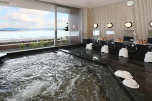 a bath room with a large pool of water at 国家公務員共済組合連合会びわこ保養所（KKRホテルびわこ） in Otsu