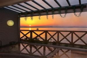 a view of a sunset from the balcony of a house at 国家公務員共済組合連合会びわこ保養所（KKRホテルびわこ） in Otsu