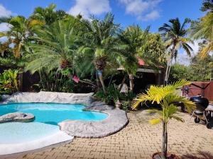 una piscina in un cortile con palme di 45 Villa la Cherry bord de mer a Le Diamant