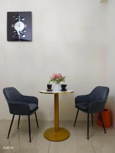 a table with two chairs and a table with flowers on it at Jing Cheng Homestay in Jincheng