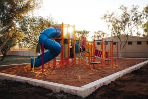 a playground with a slide in a park at Tom Price Tourist Park in Tom Price