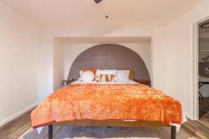 - une chambre avec un grand lit et une couverture orange dans l'établissement Stylish-Serene Midtown Getaway: Retreat for Two, à Reno