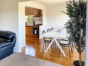 a white table and chairs in a living room at Glens Haven with Lakeviews and Outdoor Firepit in Wagga Wagga