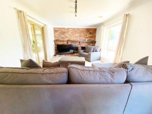 a living room with a couch and a fireplace at Glen’s Haven with Lakeviews in Wagga Wagga