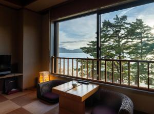 a room with a large window with a view of the ocean at Katakurinohana in Senboku