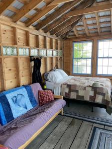 ein Schlafzimmer mit einem Bett und einem Sofa in einem Zimmer in der Unterkunft Nautilus: Floating Island Waterhouse in Monmouth