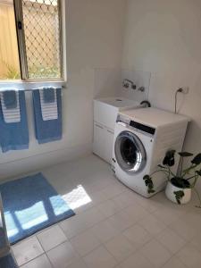 a washing machine in a bathroom with a sink at G&R Beach Cottage in Warnbro