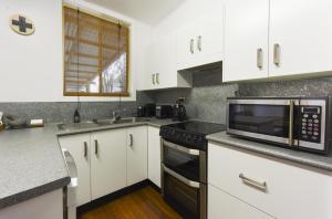 a kitchen with white cabinets and a microwave at The Grey House in Grafton
