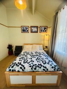 una camera da letto con un letto con un piumone bianco e nero di The Garden Cottage a Tawonga