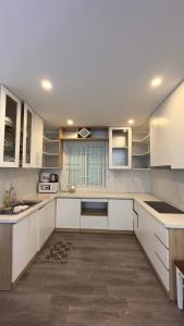 cocina grande con armarios y electrodomésticos blancos en An's Oceanus House Nha Trang en Nha Trang