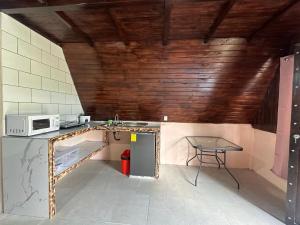 a small kitchen with a table and a microwave at Bungalow Tenorio Mountain Lodge in San Rafael