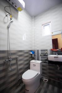 a bathroom with a toilet and a sink at HUNA House in Da Lat