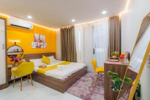 een slaapkamer met een bed, een bureau en stoelen bij Luxury Condotel Sai Gon 3 in Ho Chi Minh-stad