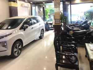 a white car parked next to a row of motorcycles at Đức Lộc 2 Hotel in Hue