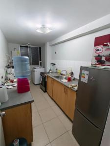 a kitchen with a refrigerator and a counter top at Departamento Condominio Arica in Arica