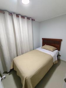 a bedroom with a bed with white curtains at Departamento Condominio Arica in Arica