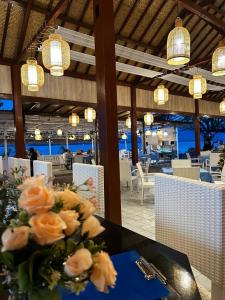 a vase of flowers on a table in a restaurant at Unzipp Bungalows Gili Air in Gili Islands