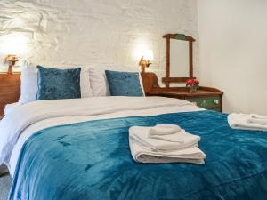 a bedroom with a large bed with towels on it at Y Beudy - Uk46191 in Llanybydder