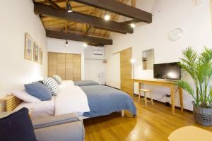 a bedroom with a large bed and a desk at リバーサイドISHIGAKI 赤瓦A棟 in Tunugusuku
