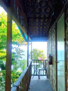 a porch of a house with a chair on it at Stay N Save B&B in Oslob