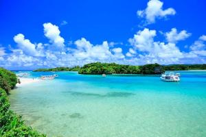 a view of a beach with boats in the water at リバーサイドISHIGAKI 赤瓦A棟 in Tunugusuku