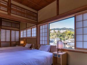 a bedroom with two beds and a large window at HOTEL CULTIA DAZAIFU in Dazaifu