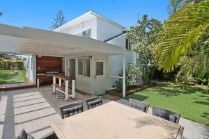 a house with a patio with a table and chairs at Oceanfront Beach House On Marine Parade in Kingscliff