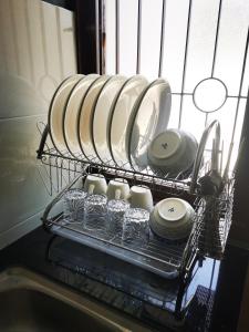un porta piatti con piatti e tazze in lavastoviglie di Retro style homestay a Ipoh