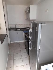 uma pequena cozinha com um frigorífico de aço inoxidável em Departamento verano la serena em La Serena
