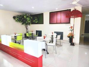 a dining room with white tables and chairs at HOTEL BALI MAKASSAR in Makassar +15 photos