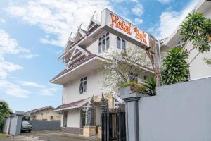 a white building with a sign in front of it at HOTEL BALI MAKASSAR in Makassar