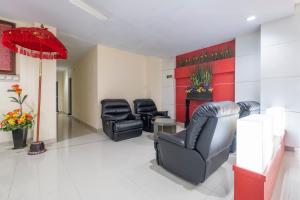 a waiting room with black chairs and a red wall at HOTEL BALI MAKASSAR in Makassar