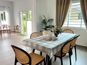 a dining room table with chairs and flowers on it at Homestay Taiping Holiday FamilyDay Please Chat First Before Booking in Kamunting