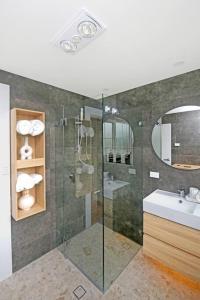 y baño con ducha y lavamanos. en Stylish Guesthouse in the Heart of Belrose, en Belrose