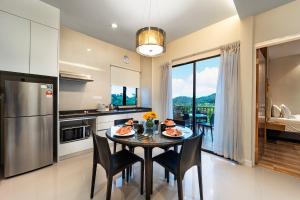 una cucina con tavolo, sedie e frigorifero di SGI Vacation Club Villa @ Damai Laut Holiday Resort a Lumut