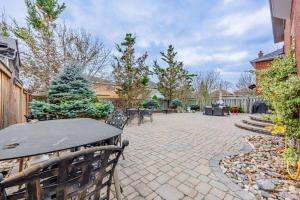 a patio with a table and chairs and trees at Cozy Haven Retreat 2Bed Basement in Whitby