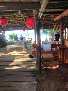 a wooden porch with people sitting at tables on the beach at Ceylon Beach Home in Galle