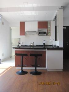 a kitchen with two bar stools in a room at Departamento Familiar Portales in Cochabamba