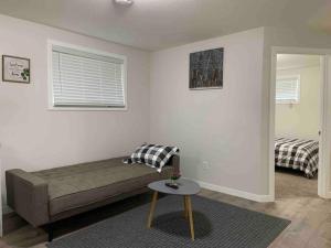 Una habitación con una cama y una mesa dentro. en Guest Suite with Queen Bed -Home Away from Home, en Regina