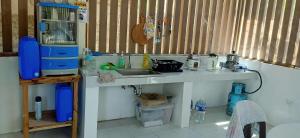 a kitchen with a sink and a counter top at CocoHut Beach House in Locaroc