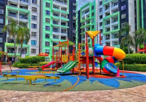 a playground in front of a large building at One Life Four Season Waterpark Guest House Manhattan Condominium in Ipoh